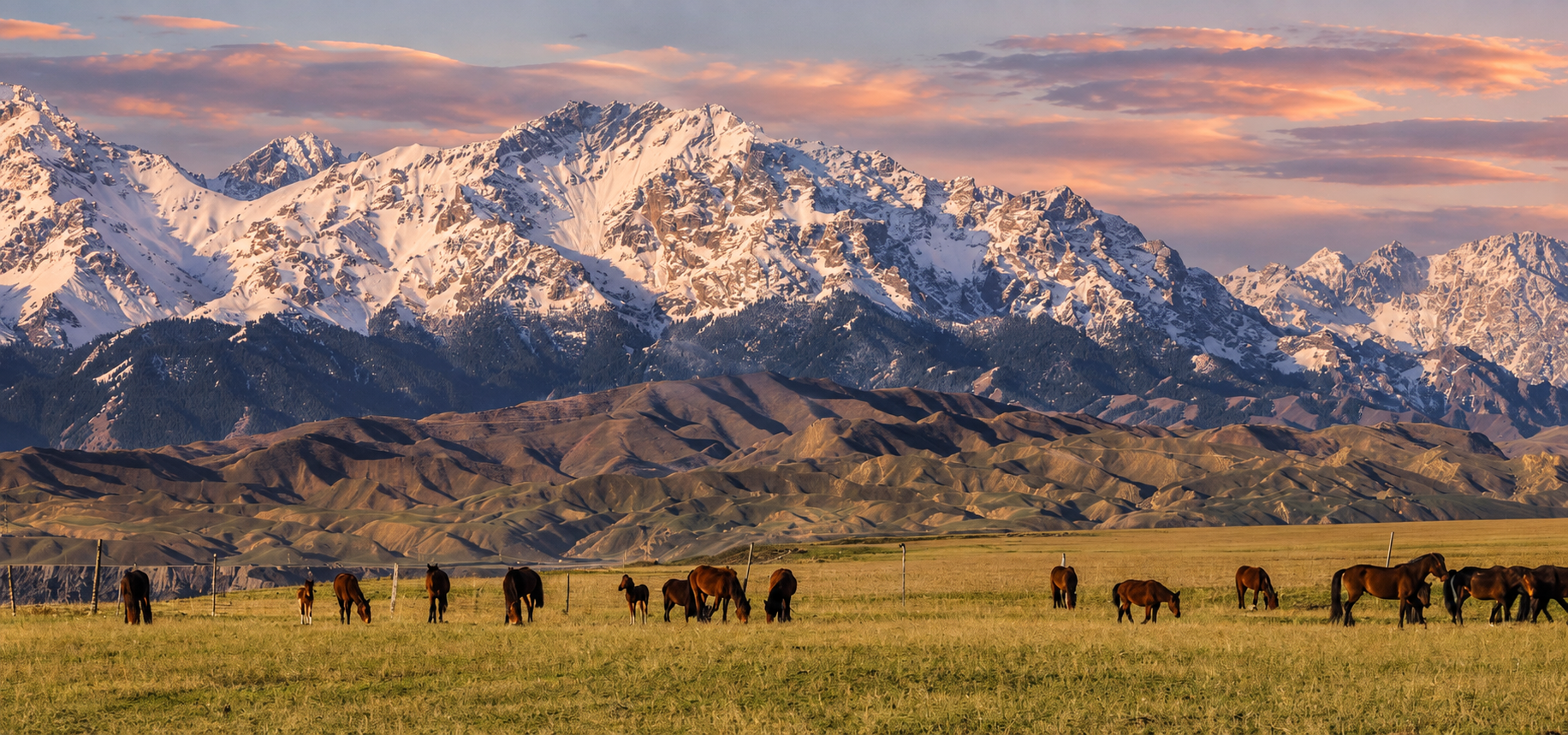 Snow-covered Xinjiang mountains beneath a warm evening sky